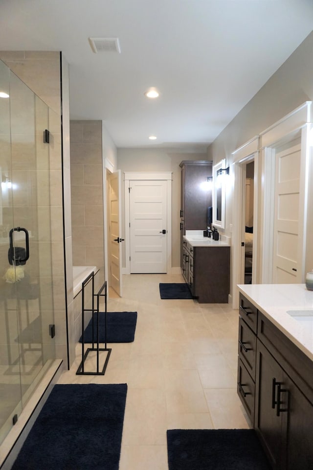 full bath featuring recessed lighting, two vanities, visible vents, a shower stall, and tile patterned flooring