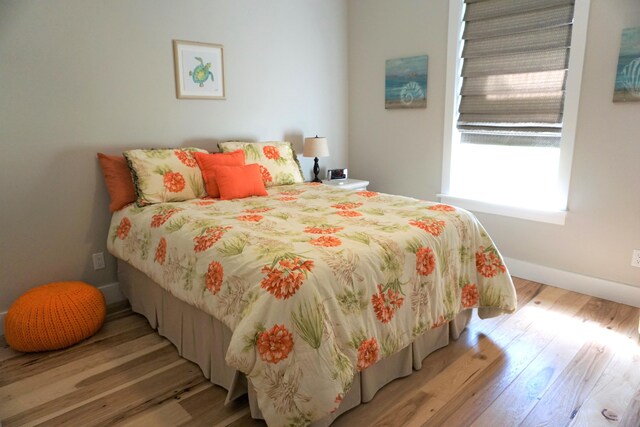 bedroom featuring light wood-style floors and baseboards