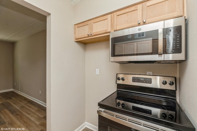 kitchen with appliances with stainless steel finishes, light brown cabinets, and dark wood-type flooring