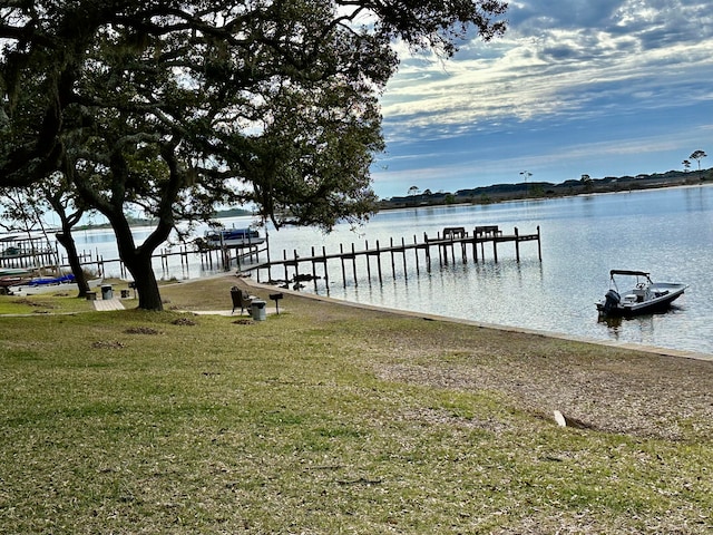 dock area with a yard and a water view