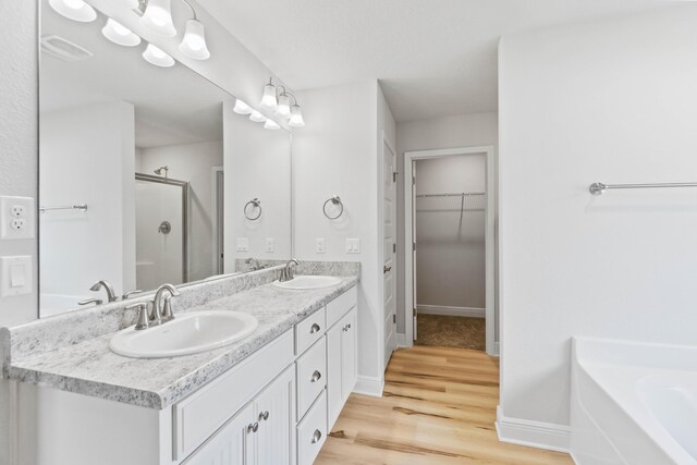 5816 Crestlake Dr, Crestview, FL 32536 - full bathroom with a stall shower, double vanity, a walk in closet, wood finished floors, and a bath