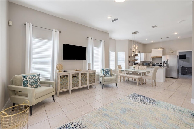 living room featuring a chandelier and light tile floors