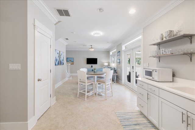 dining room with french doors, ceiling fan, light tile floors, and ornamental molding