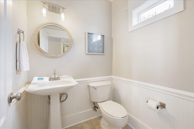 bathroom featuring tile flooring and toilet