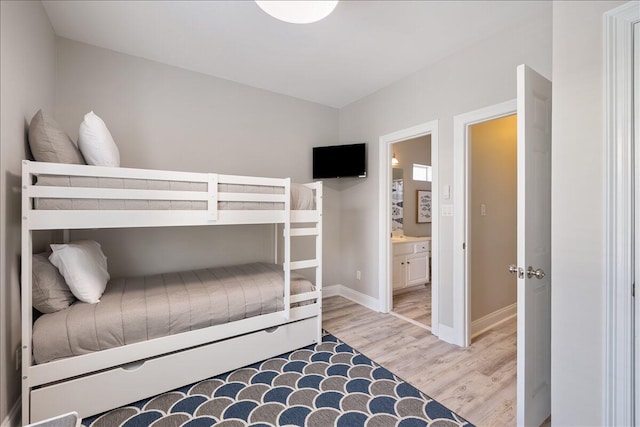 bedroom featuring connected bathroom and light wood-type flooring