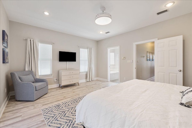 bedroom featuring ensuite bath and light hardwood / wood-style flooring