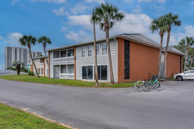 view of front of home with a balcony and a front yard