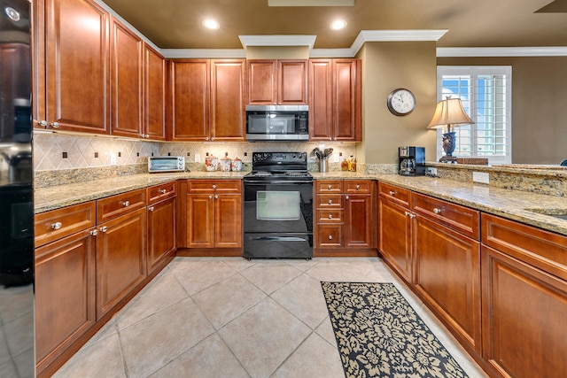 kitchen with a peninsula, light stone counters, stainless steel microwave, and black electric range oven