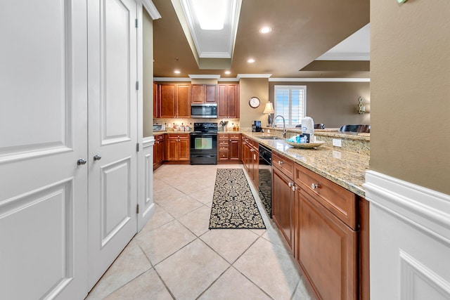 kitchen with light stone counters, ornamental molding, light tile patterned flooring, a sink, and black appliances