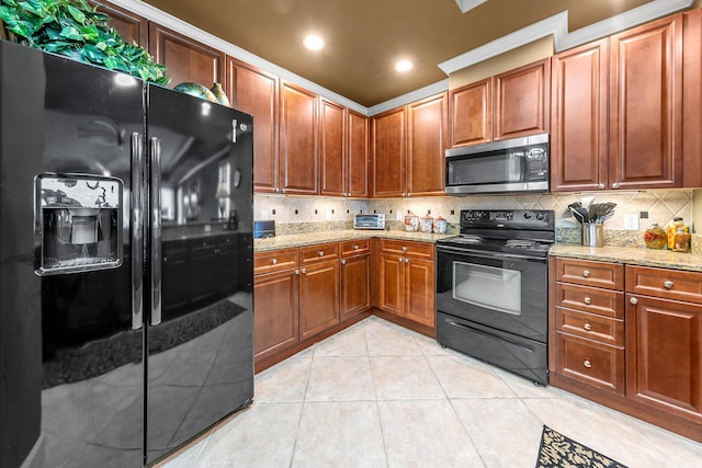 kitchen with light stone counters, light tile patterned flooring, backsplash, and black appliances