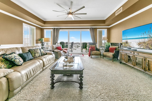 living room featuring carpet floors, a wealth of natural light, visible vents, and crown molding