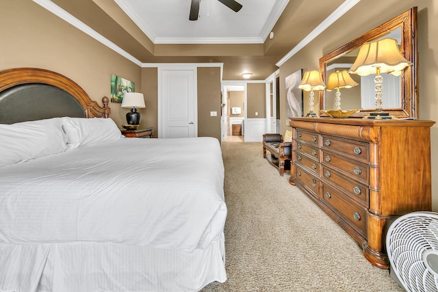 bedroom with connected bathroom, a ceiling fan, ornamental molding, a tray ceiling, and carpet