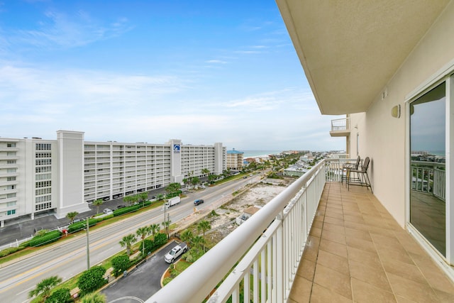 balcony featuring a water view and a city view