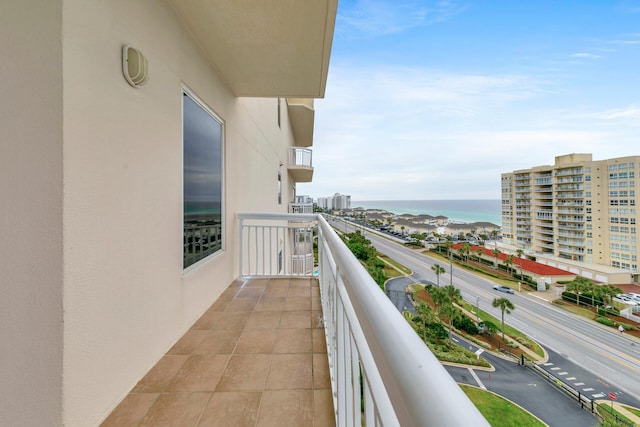 balcony featuring a water view and a city view