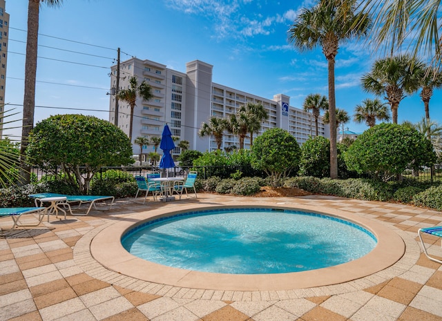 view of swimming pool featuring a patio area, fence, and a pool