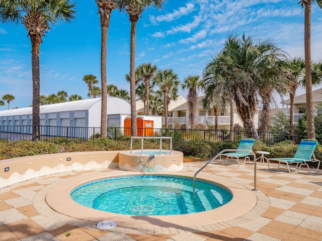 view of swimming pool with a patio area, fence, and a hot tub