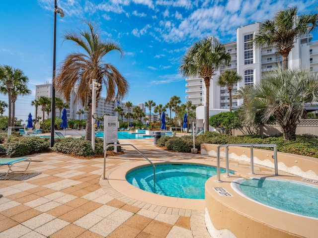 community pool featuring a community hot tub and a patio