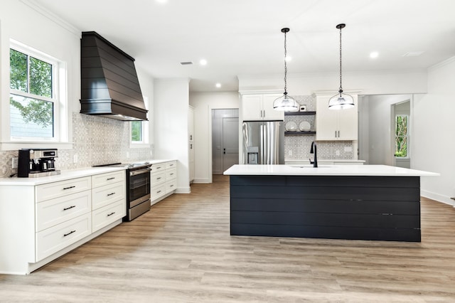 kitchen featuring appliances with stainless steel finishes, premium range hood, decorative backsplash, and a center island with sink