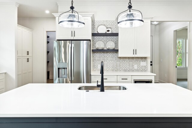 kitchen with a center island with sink, sink, and stainless steel fridge