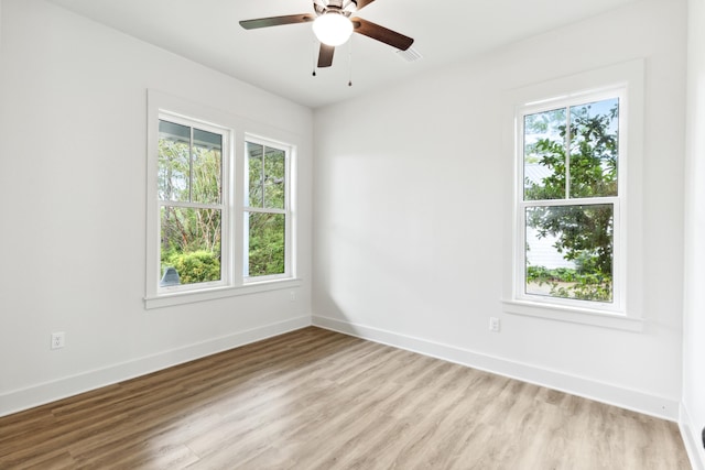 unfurnished room with ceiling fan, plenty of natural light, and wood-type flooring