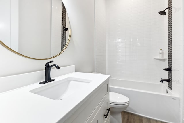 full bathroom with vanity, toilet, wood-type flooring, and bathtub / shower combination