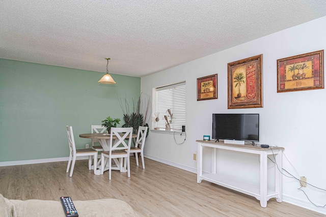 dining room featuring a textured ceiling and light wood-type flooring