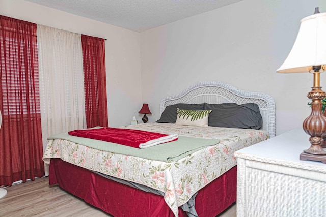 bedroom with light hardwood / wood-style flooring and a textured ceiling