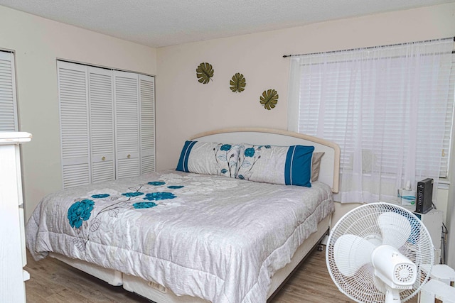 bedroom with light hardwood / wood-style flooring and a textured ceiling