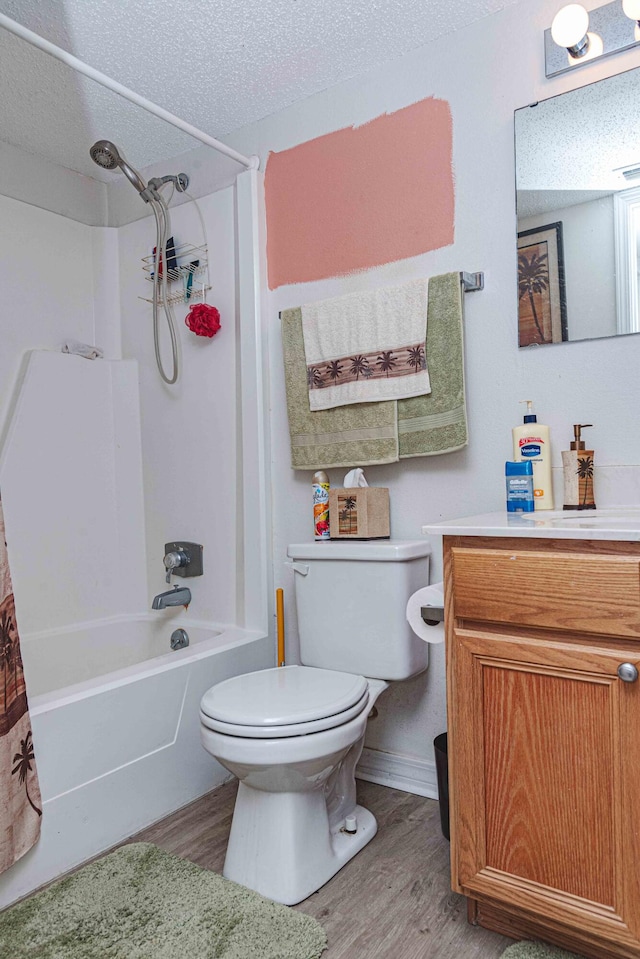 full bathroom featuring wood-type flooring, toilet, vanity, and a textured ceiling