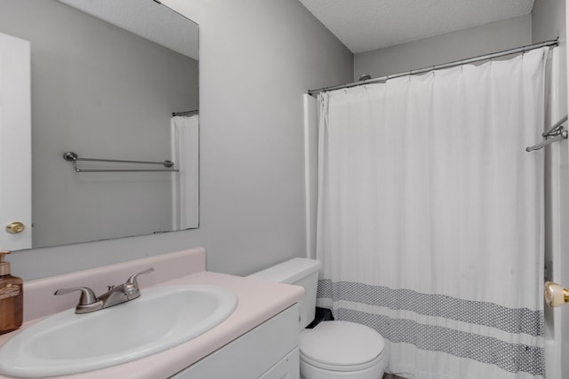 bathroom featuring a textured ceiling, vanity, and toilet