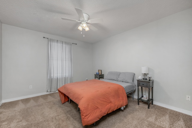 carpeted bedroom featuring ceiling fan and a textured ceiling