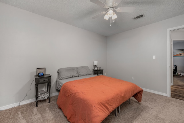 bedroom with a textured ceiling, light hardwood / wood-style flooring, and ceiling fan