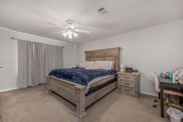 carpeted bedroom with ceiling fan and a textured ceiling