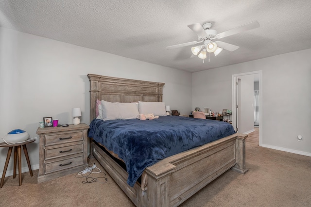 bedroom with ensuite bath, a textured ceiling, ceiling fan, and light carpet