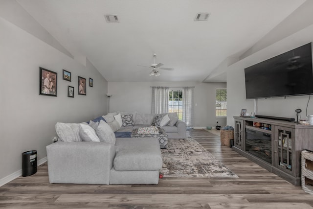 living room featuring hardwood / wood-style floors, lofted ceiling, ceiling fan, and a fireplace