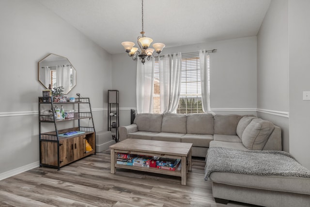 living room featuring wood-type flooring and a chandelier