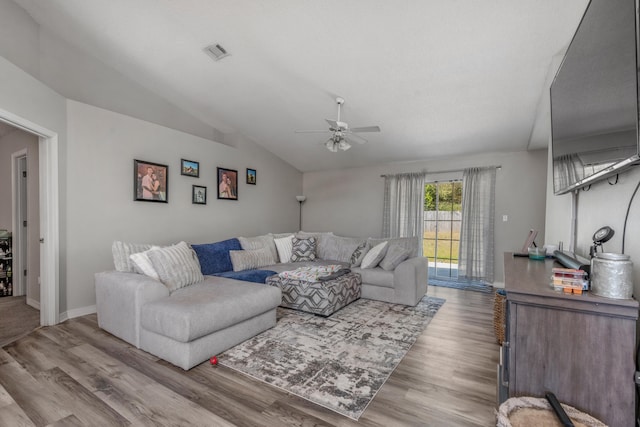 living room featuring light hardwood / wood-style floors, ceiling fan, and vaulted ceiling