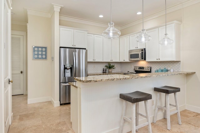 kitchen with decorative light fixtures, white cabinetry, stainless steel appliances, light stone counters, and tasteful backsplash