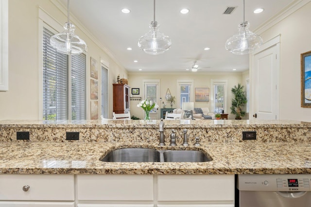 kitchen featuring pendant lighting, dishwasher, and light stone counters