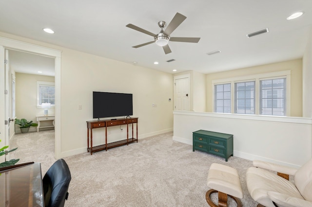 living room with light colored carpet, ceiling fan, and a wealth of natural light