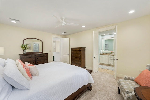 carpeted bedroom featuring ensuite bath and ceiling fan