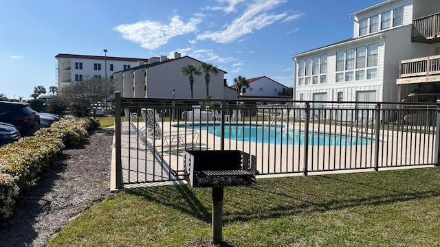 view of swimming pool with a yard