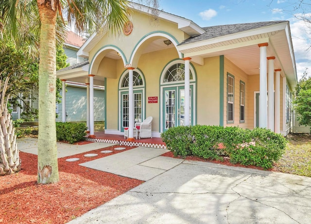 mediterranean / spanish house with covered porch and french doors