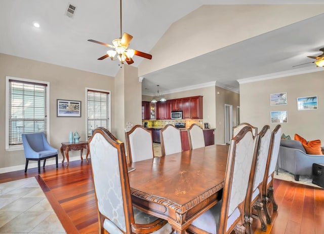 tiled dining area with ornamental molding, ceiling fan, and lofted ceiling