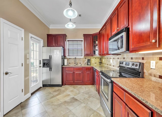 kitchen featuring light stone countertops, decorative light fixtures, appliances with stainless steel finishes, backsplash, and ornamental molding