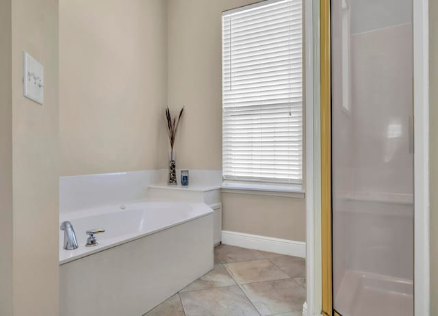 bathroom with a healthy amount of sunlight, tile floors, and a bathing tub