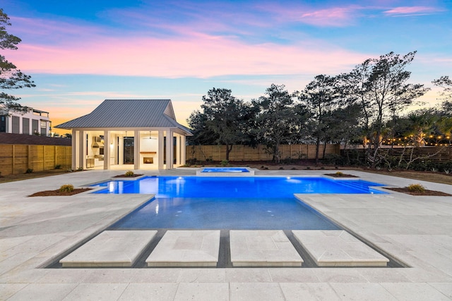 pool at dusk featuring a patio