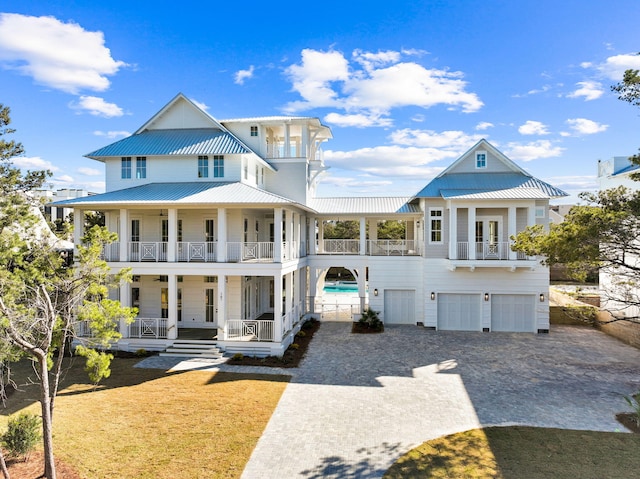 view of front of home with a garage, a balcony, and a porch