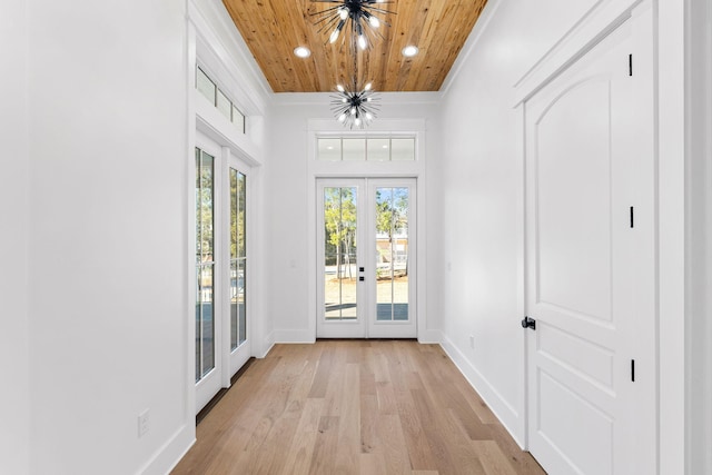 doorway to outside with light wood-type flooring, wood ceiling, ornamental molding, french doors, and an inviting chandelier