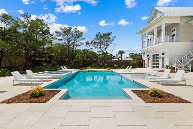 view of pool featuring a patio area and an in ground hot tub